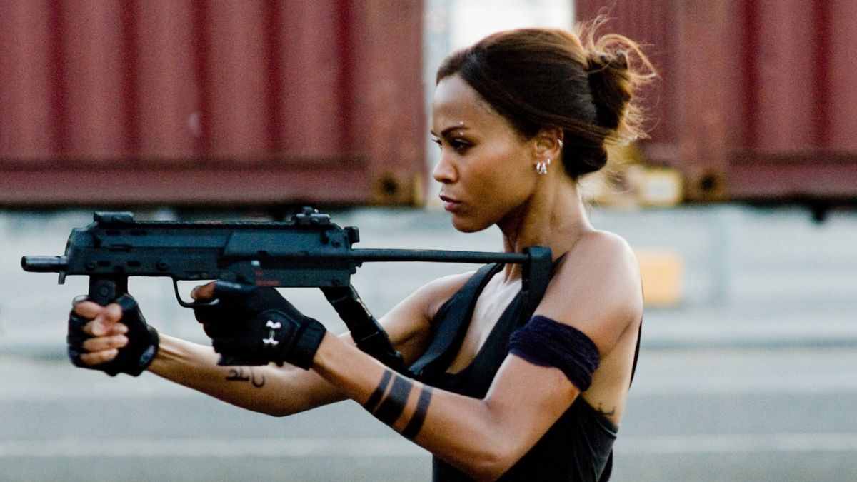 Fraierii Netflix. În imagine: Zoe Saldana cu armă în mâini